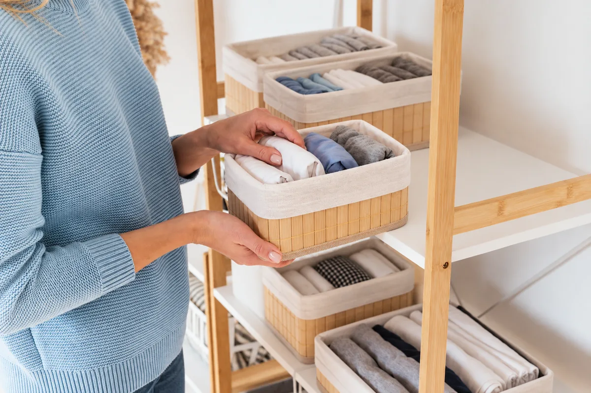 Organização de roupas em cestos forrados nas prateleiras.